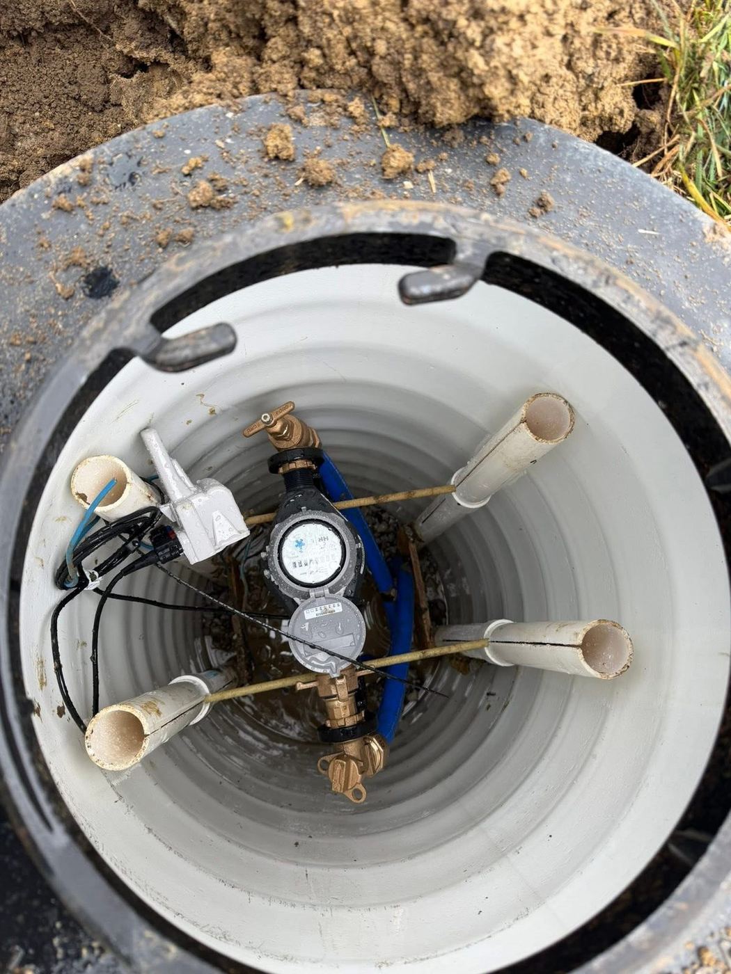 Water meter pit with the meter and service lines set inside the barrel