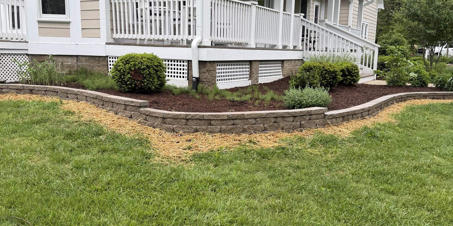Segmental block retaining wall built around a planting bed at a front porch