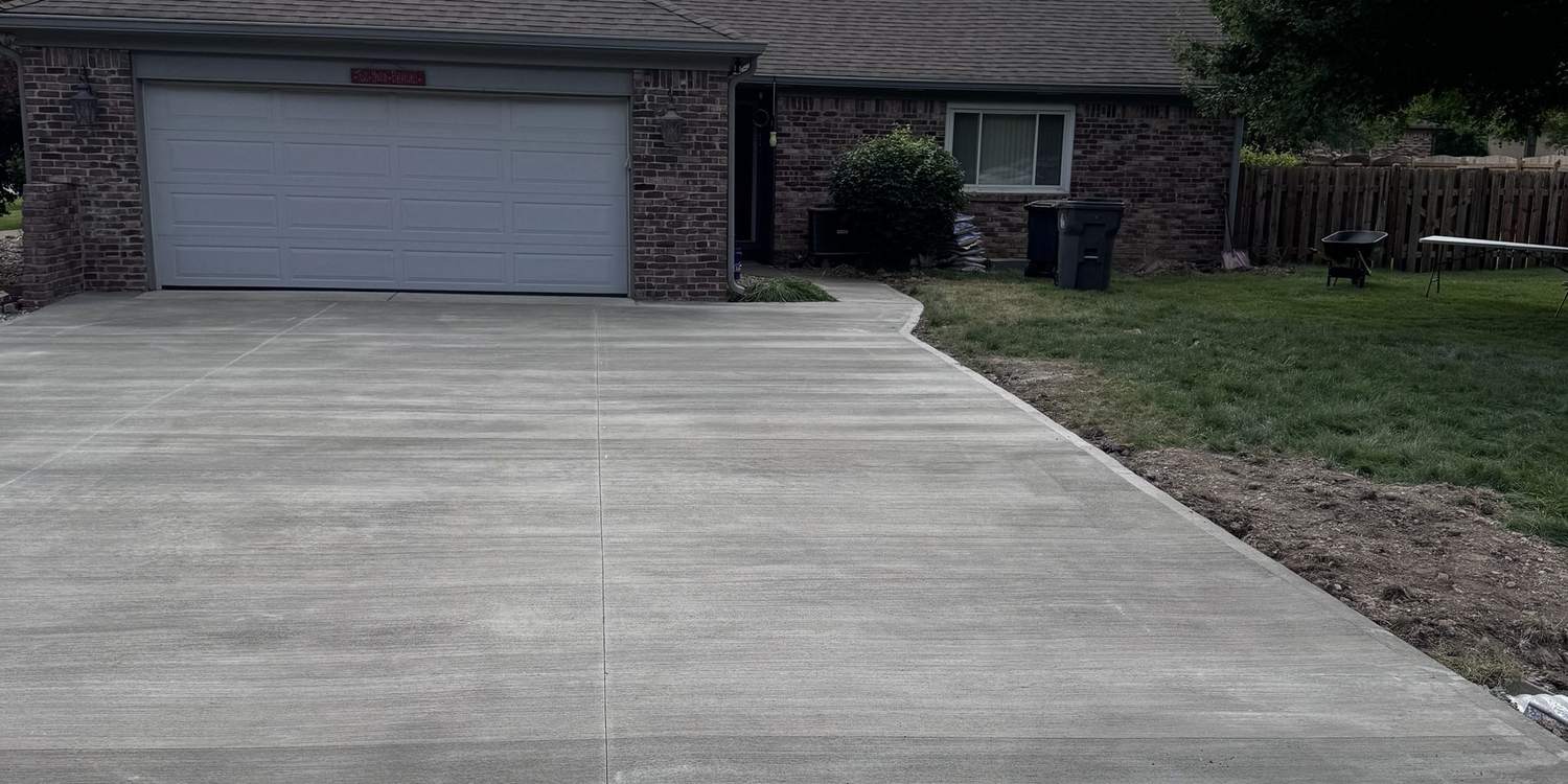Finished poured concrete driveway running from the street to a two car garage