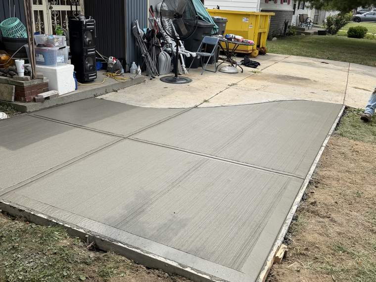 Wide concrete driveway poured and floated in front of a detached garage
