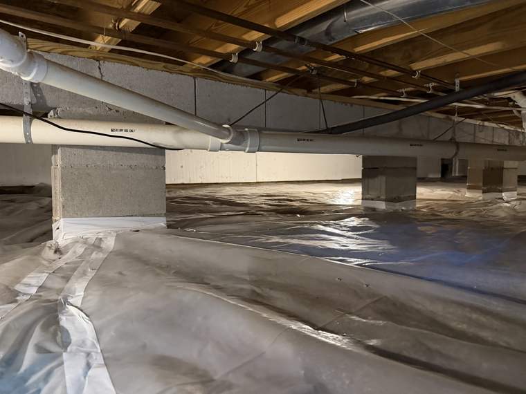 Wide view of a crawlspace with the liner installed and seams lapped