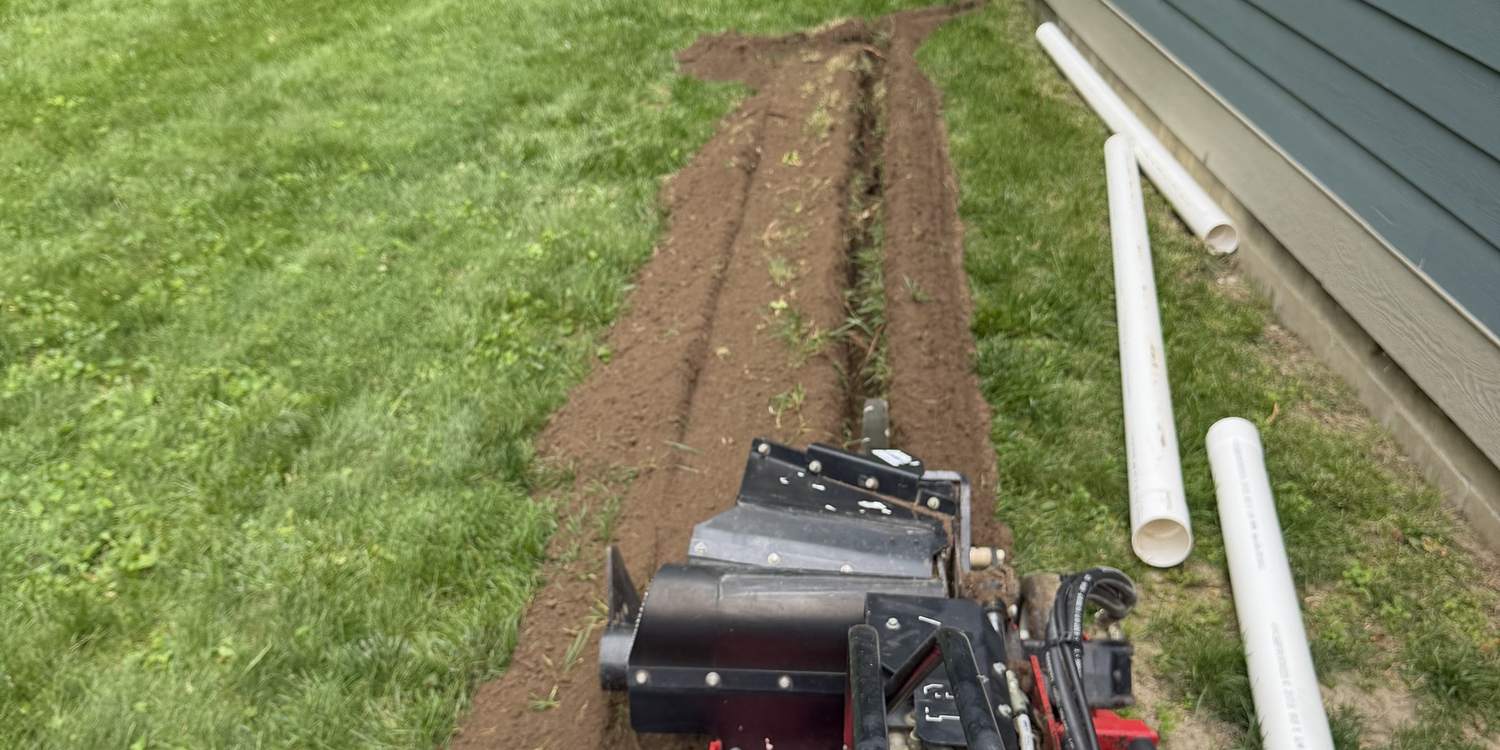 Directional boring machine running a new line beside a house without open trenching