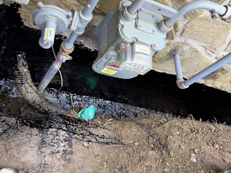 Utility service and meter connection exposed in an open trench for replacement